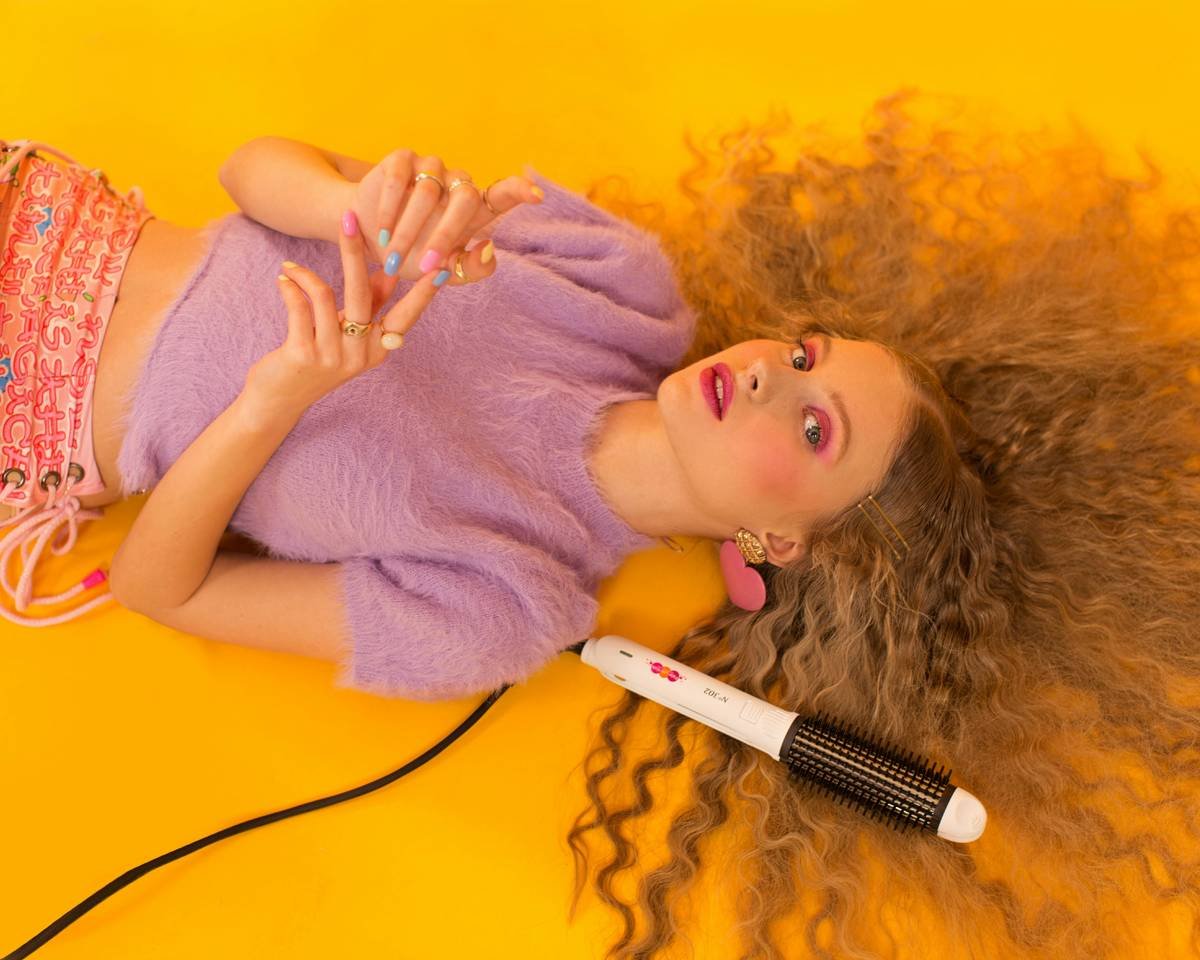 Infographic comparing 1990s vs. 2024 hair crimper tech: older models had metal plates, no temp control; modern ones feature ceramic plates, digital displays, and auto-shutoff